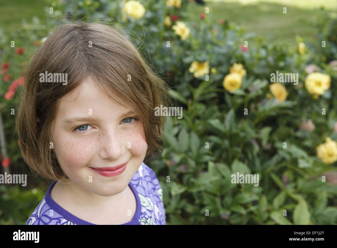 Un enfant dans un jardin à up and smiling Banque D'Images