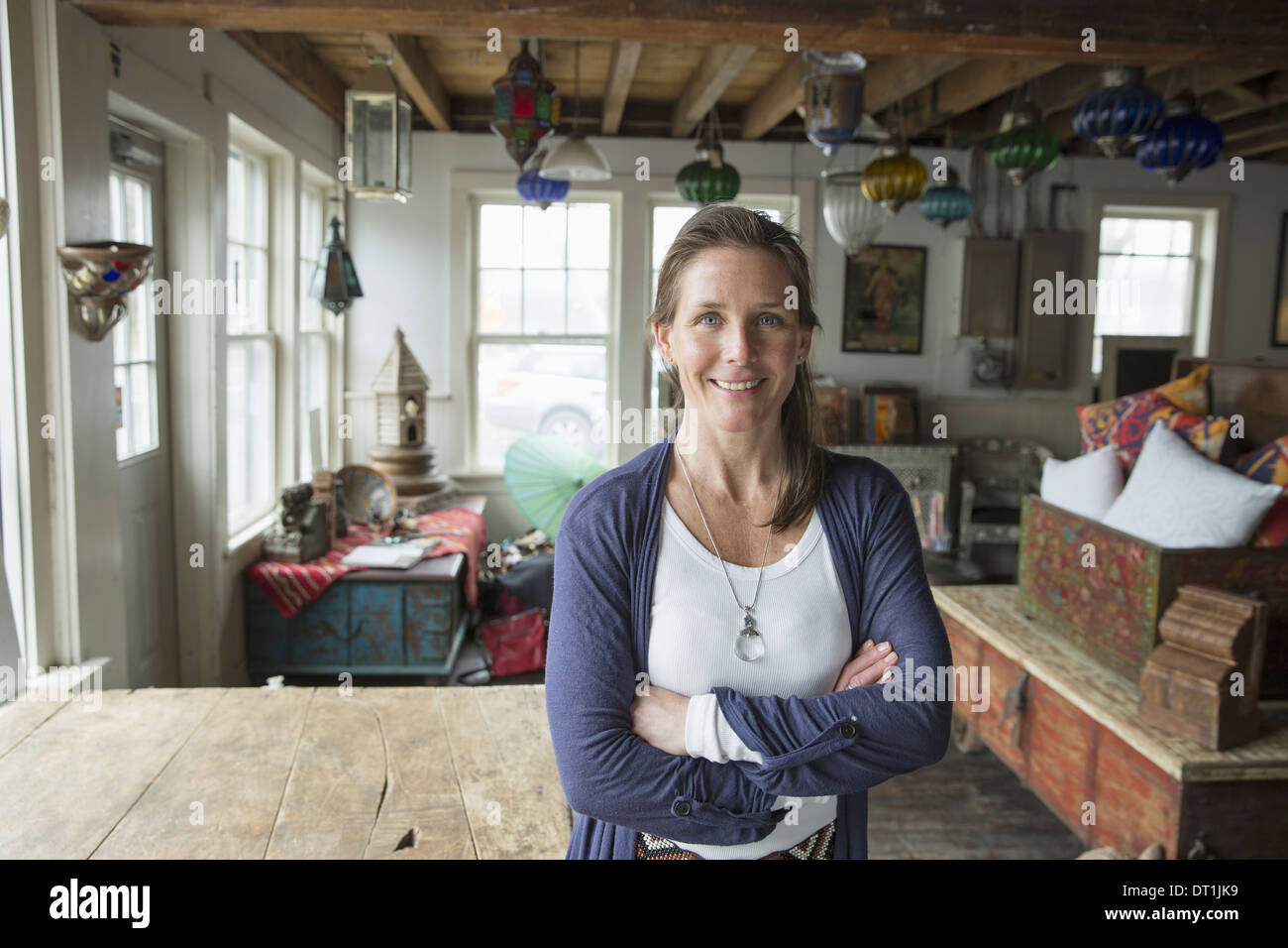 Une femme dans un magasin d'antiquités dans une petite ville avec des objets et meubles du passé Banque D'Images