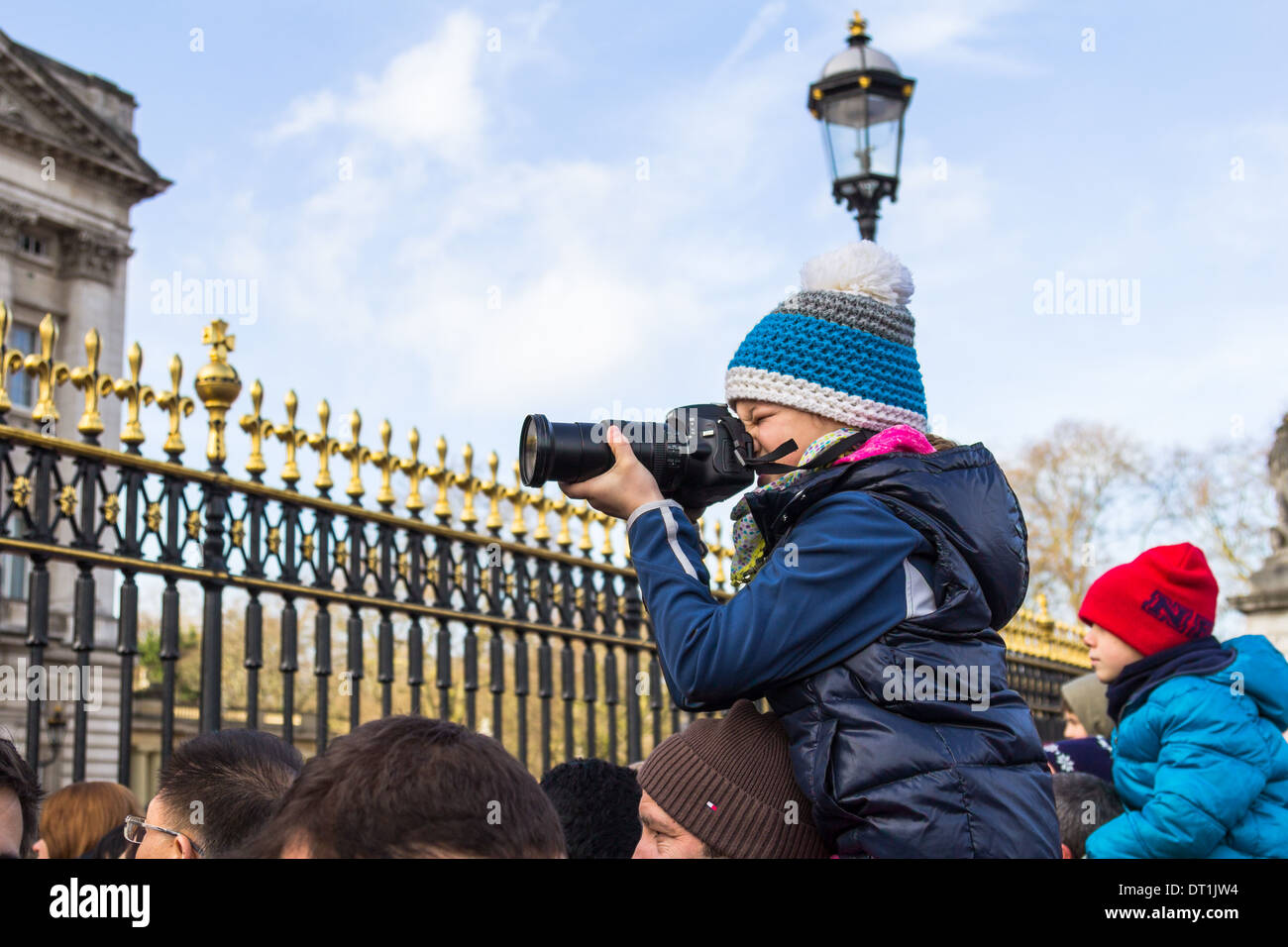 LONDON, UK, 2e mars 2014 : un jeune photographe à prendre des photos du Palais de Buckingham au sommet d'une des épaules du Mans Banque D'Images