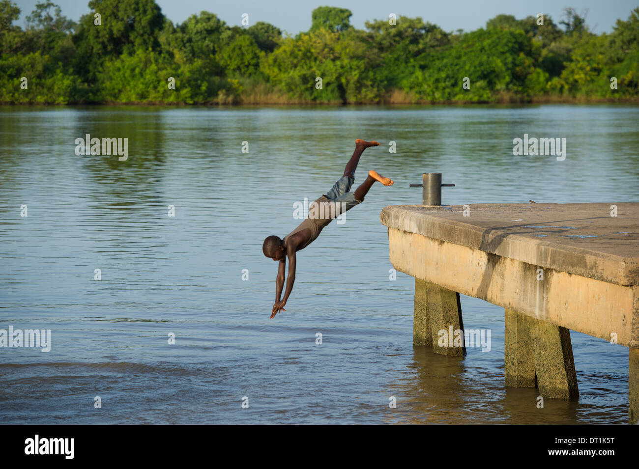 Garçon de plonger dans le fleuve Gambie à partir de la jetée, sur l'île de MacCarthy Janjangbureh, Gambie Banque D'Images