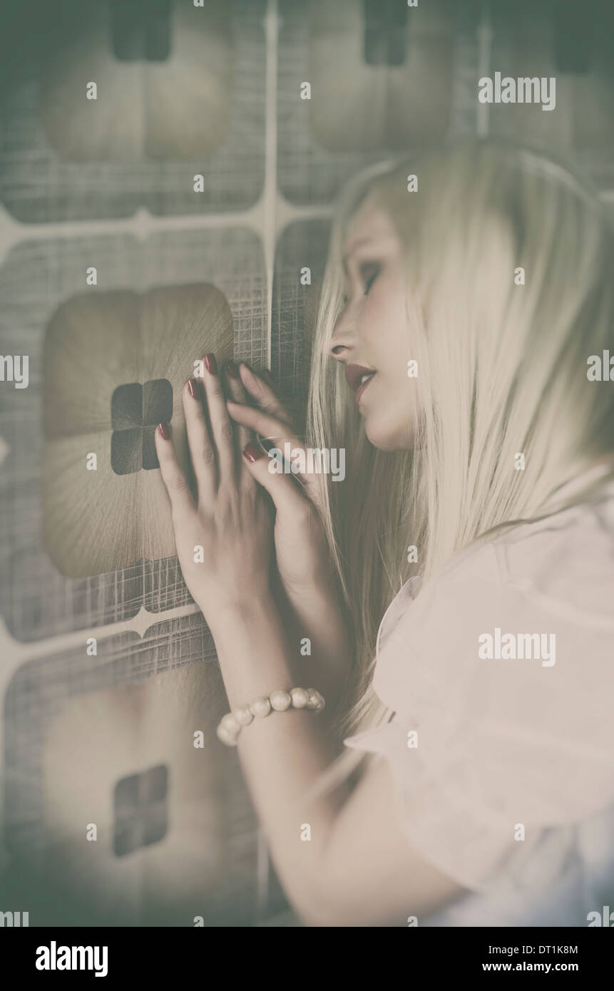 Femme triste appuyé contre le mur Banque D'Images