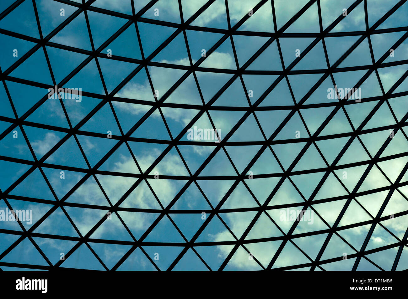 Vu à travers un cadre à motifs triangulaires et ciel bleu nuages de toit Banque D'Images