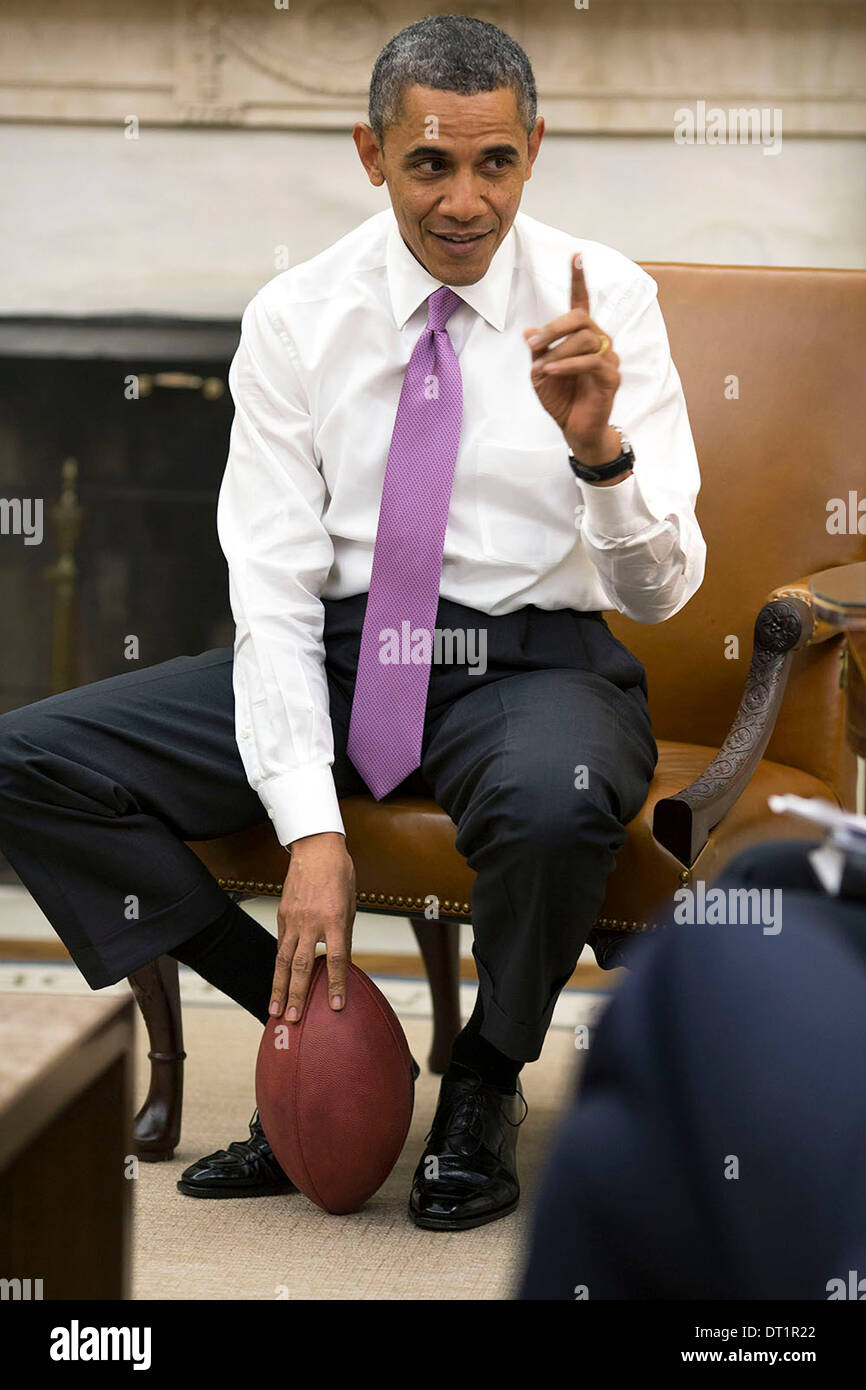 Le président américain Barack Obama est titulaire d'un football comme il se réunit avec les conseillers senior dans le bureau ovale de la Maison Blanche, 11 décembre 2013 à Washington, DC. Banque D'Images
