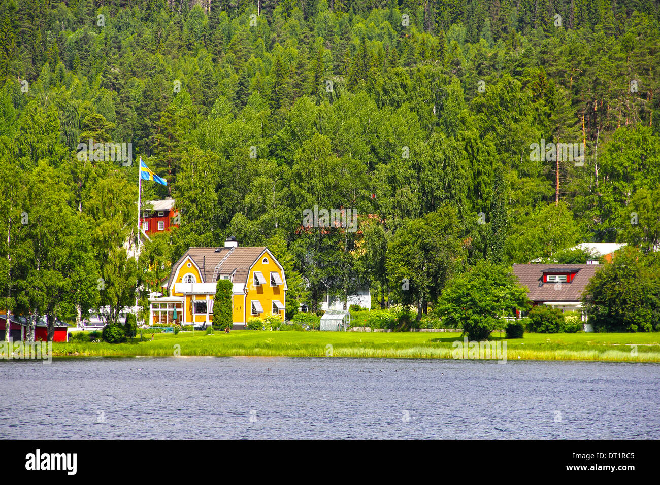 Petit village suédois sur la rive de lac calme en été Banque D'Images