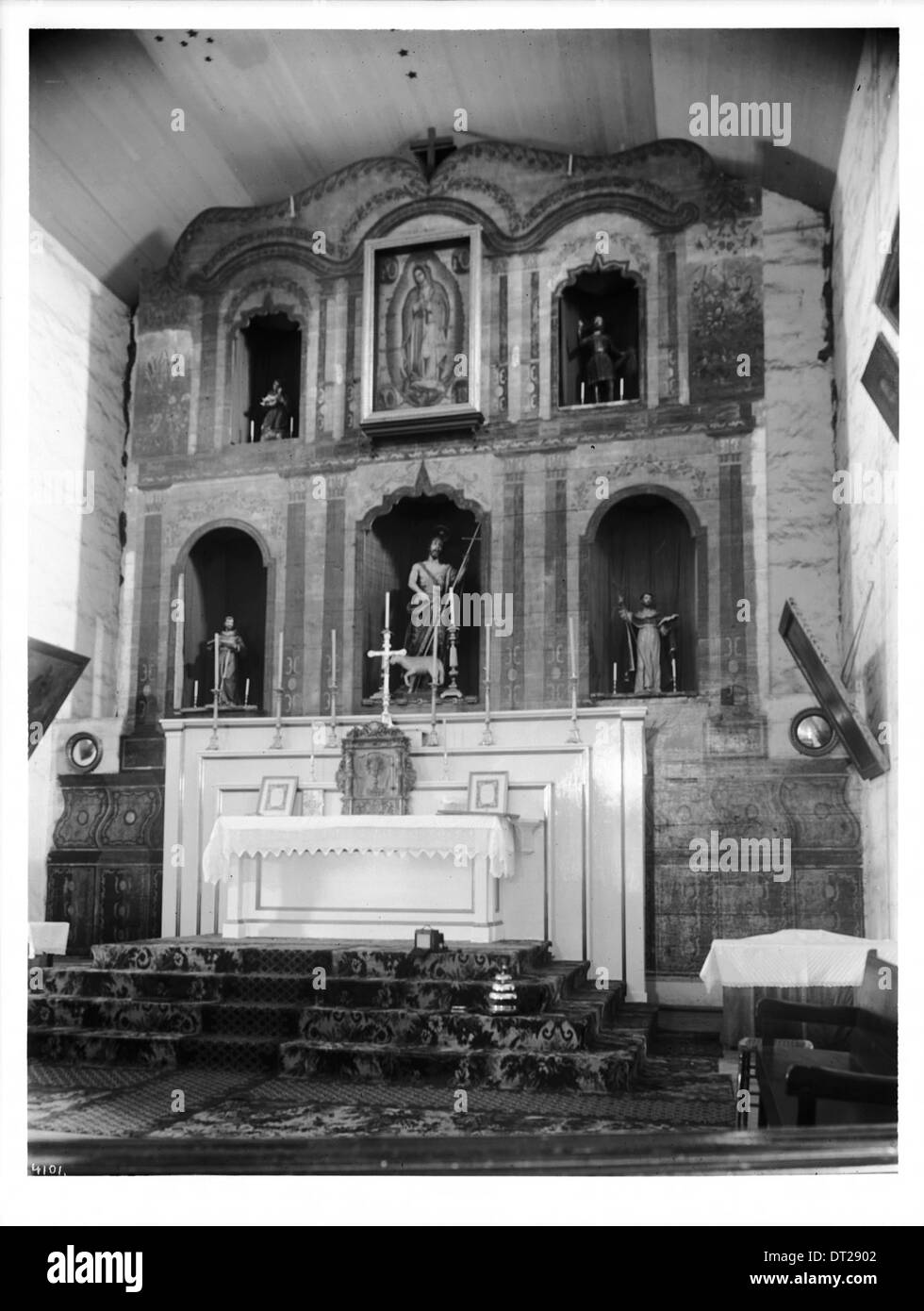 Une vue intérieure de l'autel principal de la Mission San Juan Bautista, capturée vers 1903, mettant en valeur l'architecture religieuse historique. Banque D'Images