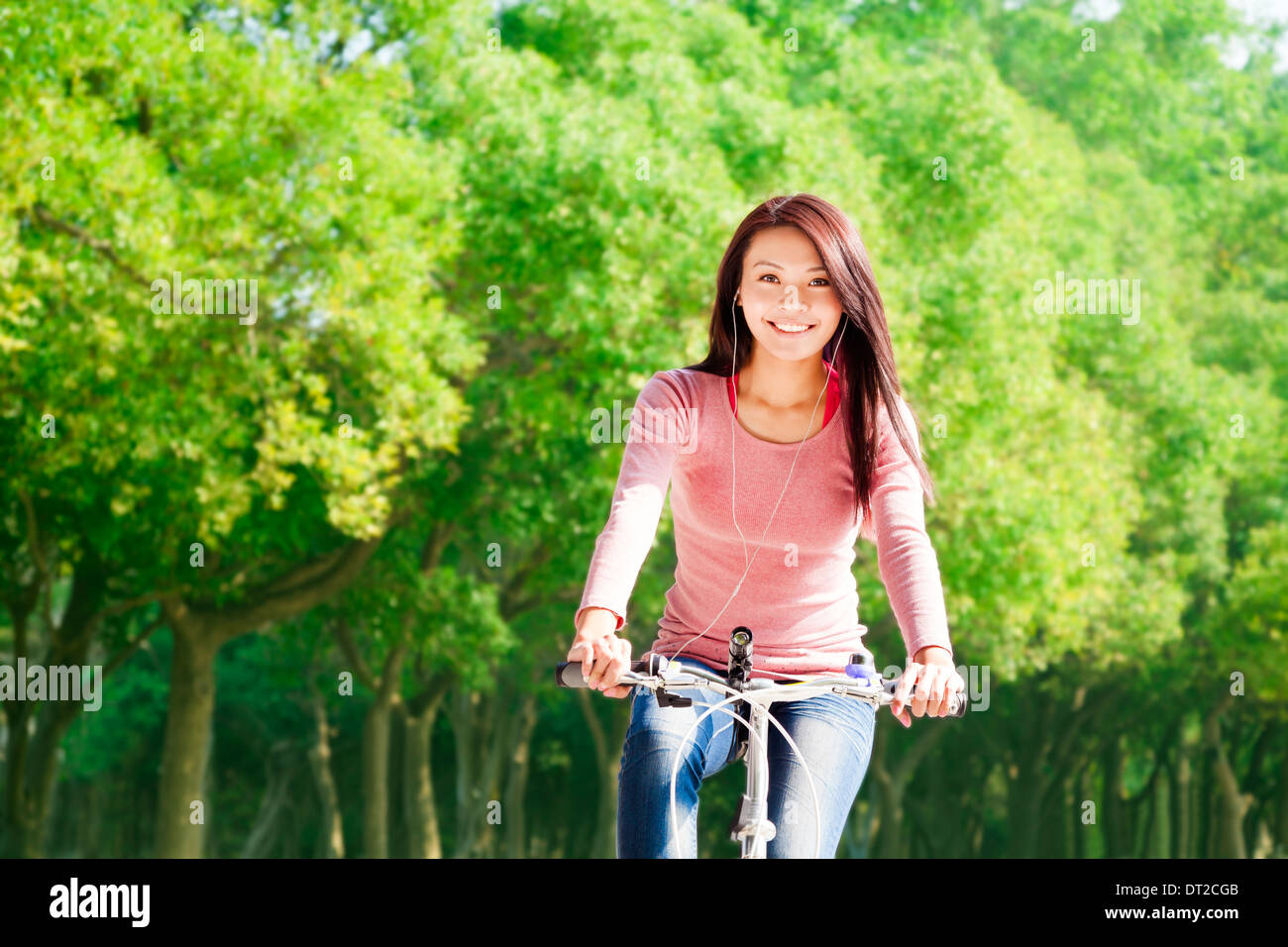 Young woman riding bike et listening music Banque D'Images