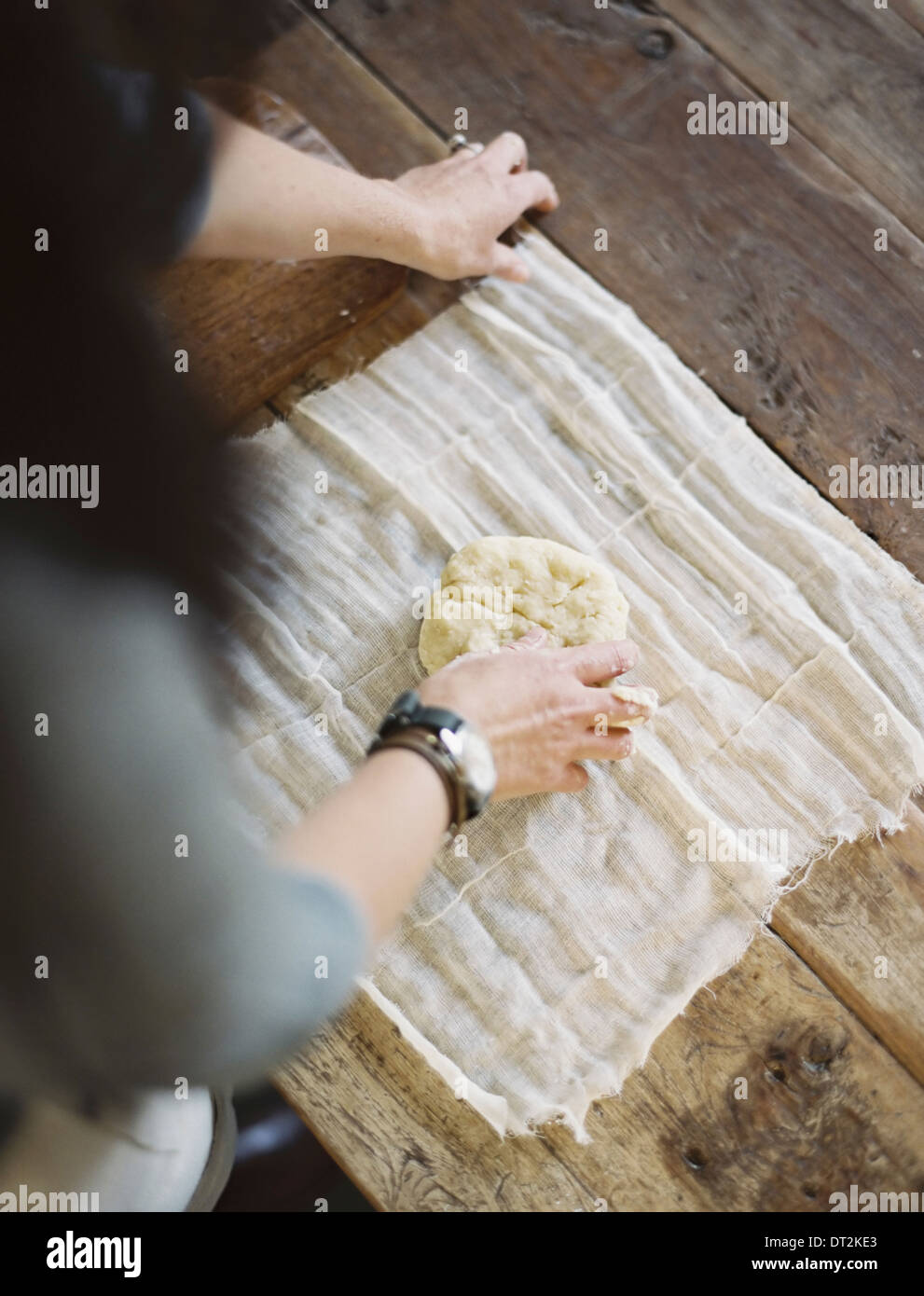 Une table de cuisine en vue de dessus d'une femme rétractable la pâtisserie fraîche dans un tissu de mousseline pour la maintenir fraîche Banque D'Images