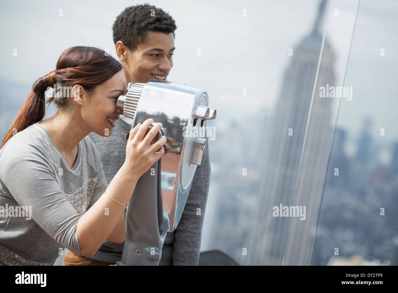 Vue sur cityA jeune couple à la recherche par le télescope Banque D'Images