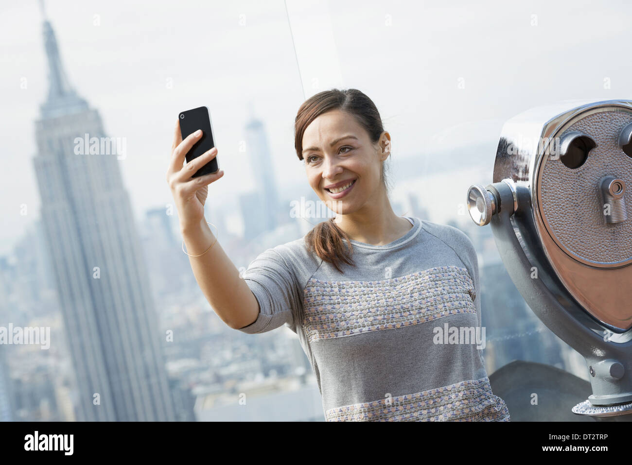 Vue sur cityA woman using her smart phone pour photographier la vue Banque D'Images Vue sur cityA woman using her smart phone pour photographier la vue Banque D'Images