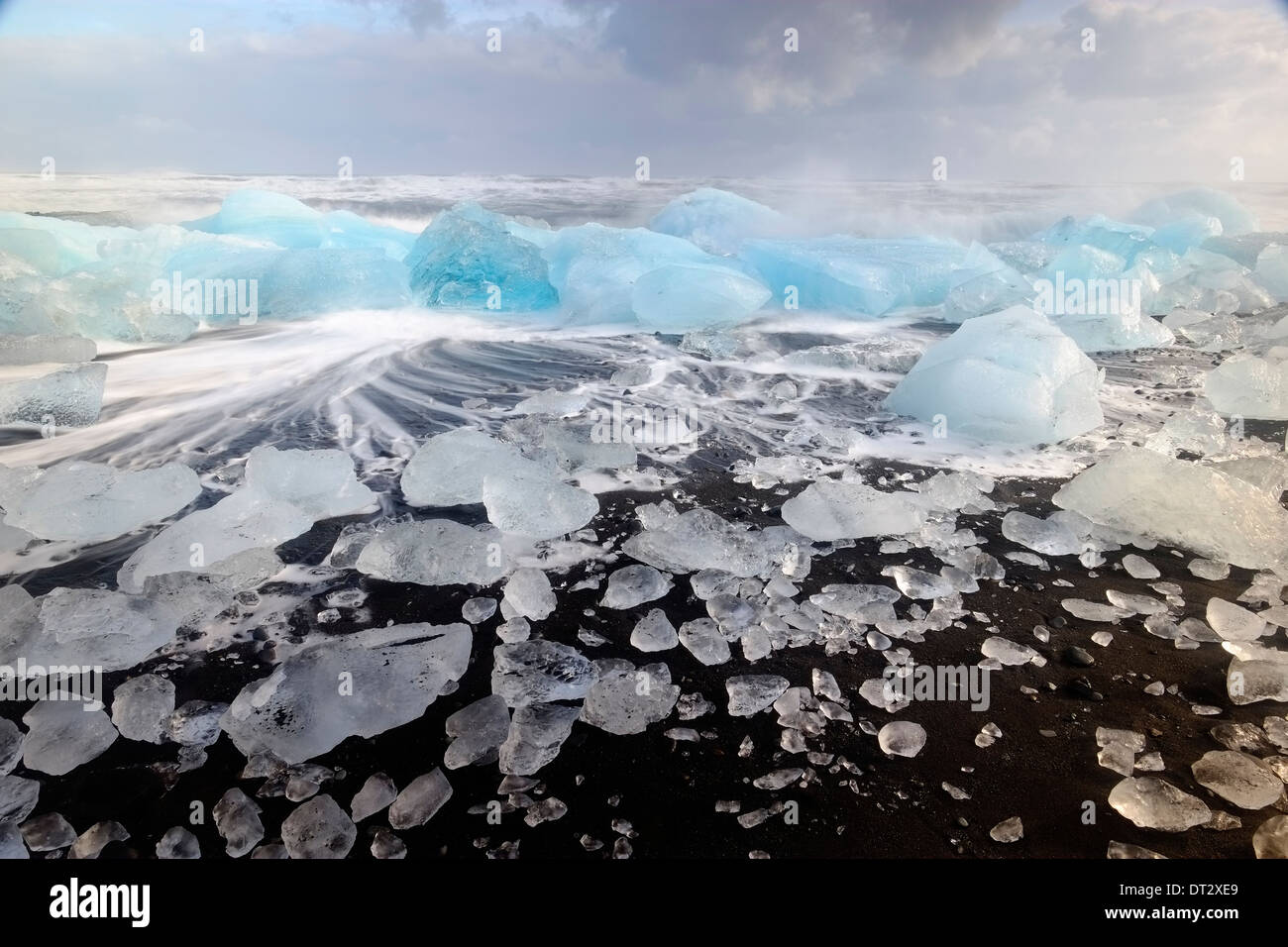 Les icebergs et les vagues sur la plage de Jokulsarlon, région polaire, le sud de l'Islande Banque D'Images