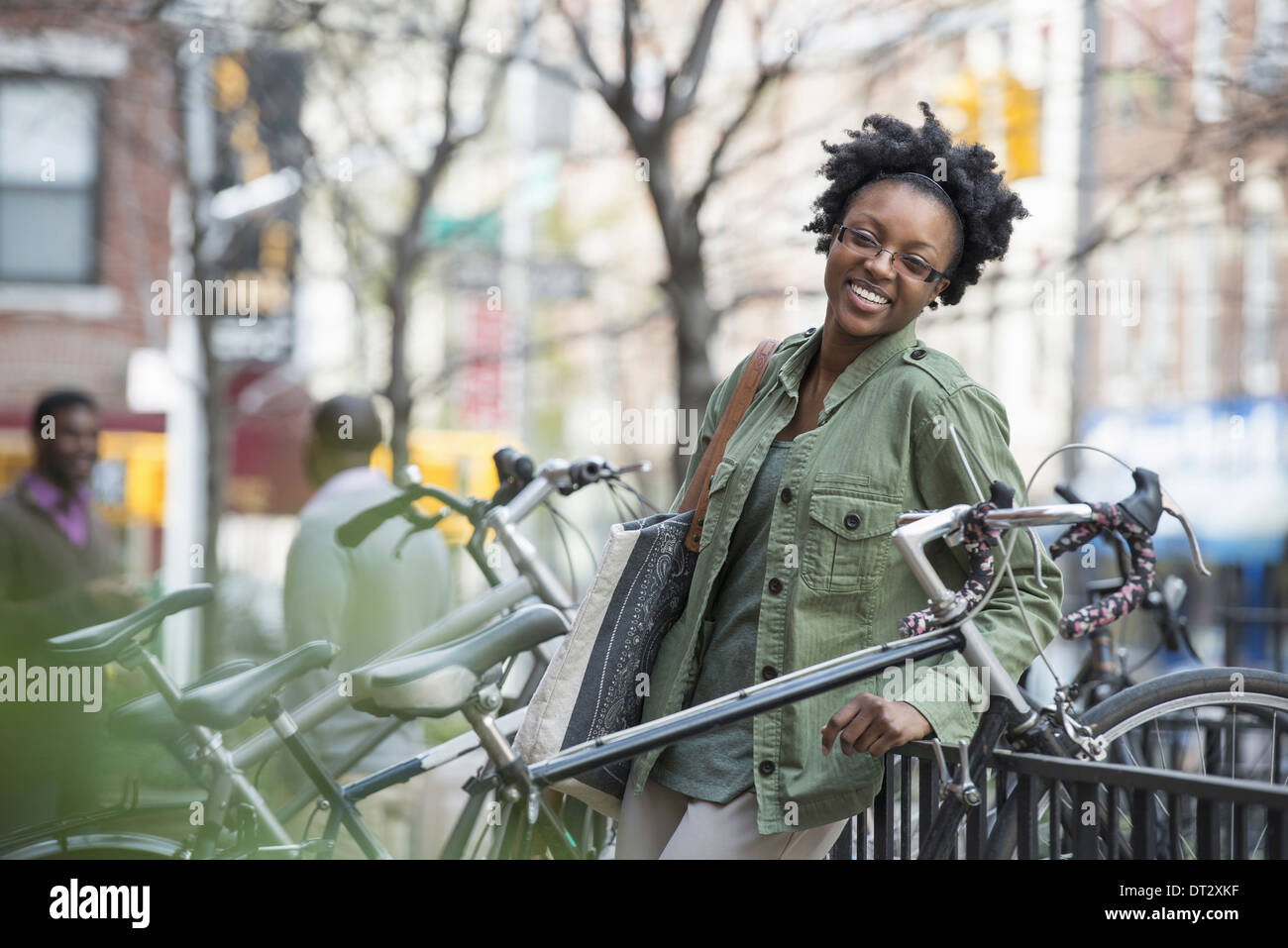 Une femme appuyée contre une balustrade à côté d'un support à bicyclettes Banque D'Images