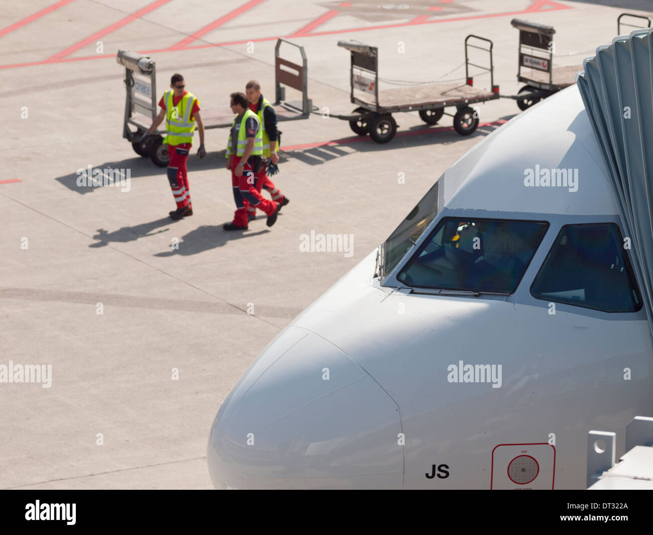 Les travailleurs de l'équipe au sol passe par un avion de passagers stationné à l'Aéroport International de Zurich Kloten après le chargement / déchargement des bagages enregistrés Banque D'Images