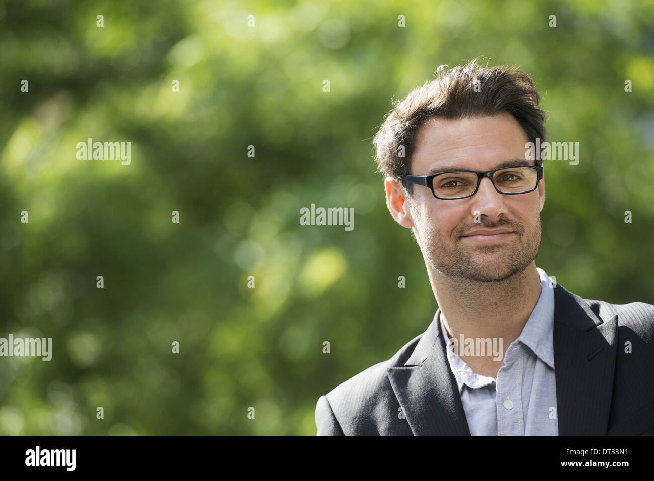 Un homme aux cheveux noirs courts et verres Smiling at the camera Banque D'Images