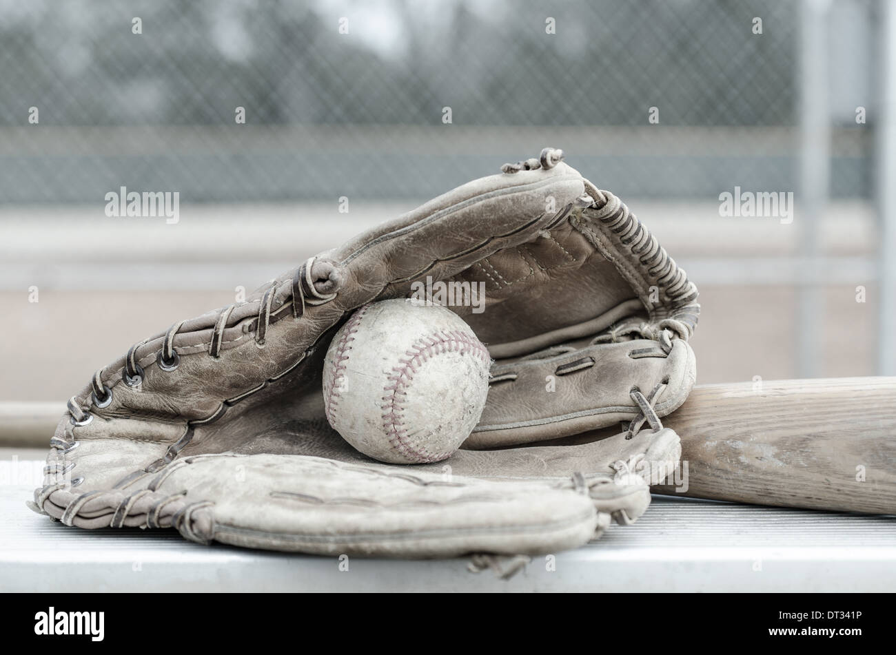 Jeu de l'Amérique avec le baseball dans la main avec bat sur banc. Sur le terrain de baseball en arrière-plan. Banque D'Images