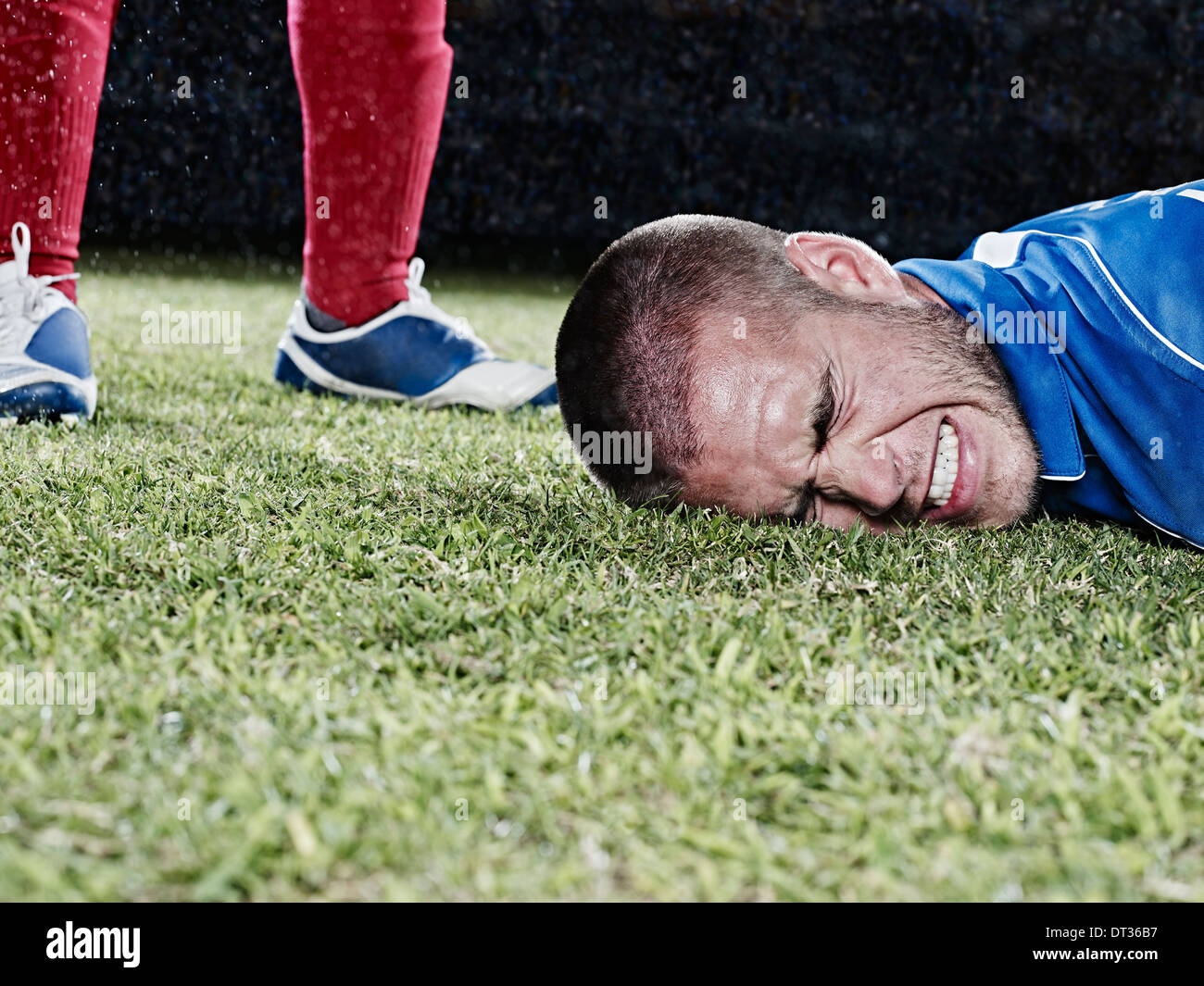 Joueur de football tomber sur terrain Banque D'Images