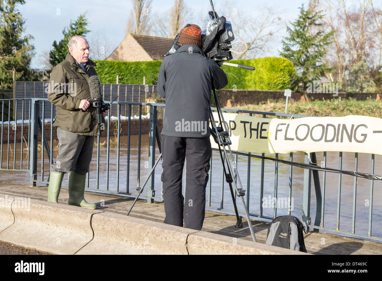 Burrowbridge, Somerset, Royaume-Uni. 8 février 2014. Le député conservateur M. Ian Liddell-Grainger interviewée par BBC News le 8 février 2014 Comité permanent sur le pont au-dessus de la rivière Parrett sur l'A361 à Burrowbridge, Somerset. En raison de fortes précipitations, les rivières Parrett et le ton sont sorties de leur lit l'inondation des terres agricoles à proximité des maisons et laissant sous l'eau. À la suite de visites par Lord Chris Smith et David Cameron hier, une inondation grave reste alerte et certains occupants a dit d'évacuer. Le Somerset Levels ont connu les pires inondations de l'histoire vivante. Credit : Nick Cable/Alamy vivre Banque D'Images