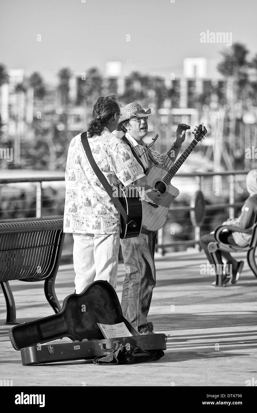 Photo en noir et blanc de deux Street Performers (Buskers) jouant devant la foule sur Redondo Pier, Los Angeles, Californie, États-Unis Banque D'Images