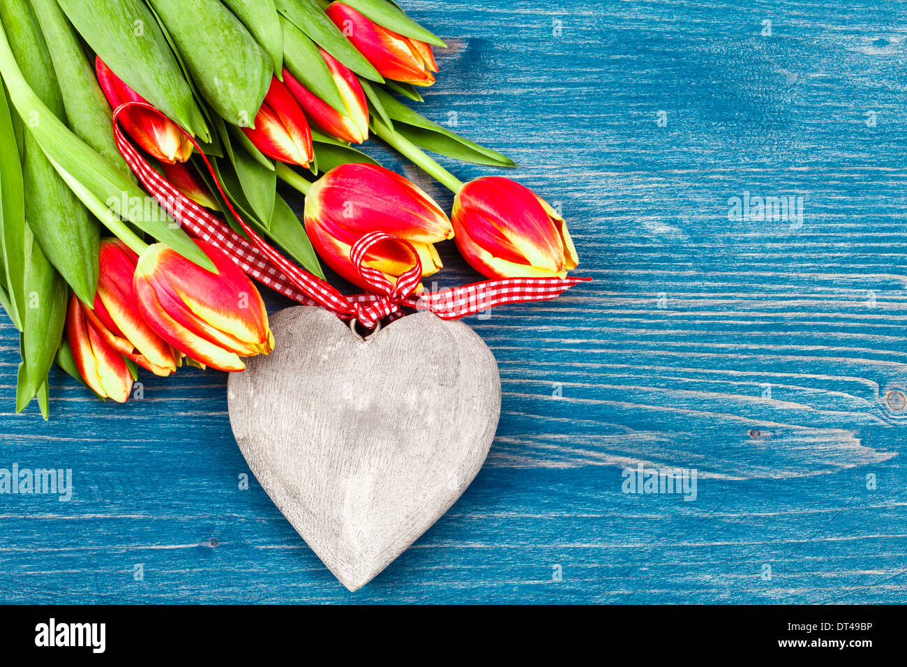 Tulip bouquet sur fond bleu et coeur en bois Banque D'Images