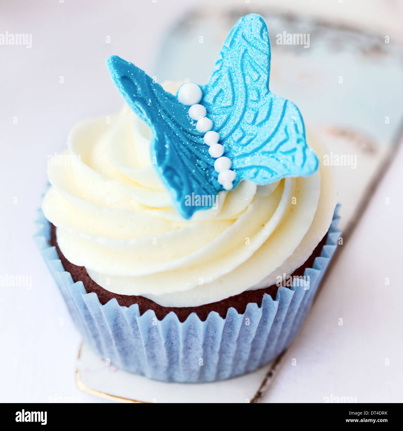 Cupcake décoré d'un papillon sucre bleu Banque D'Images