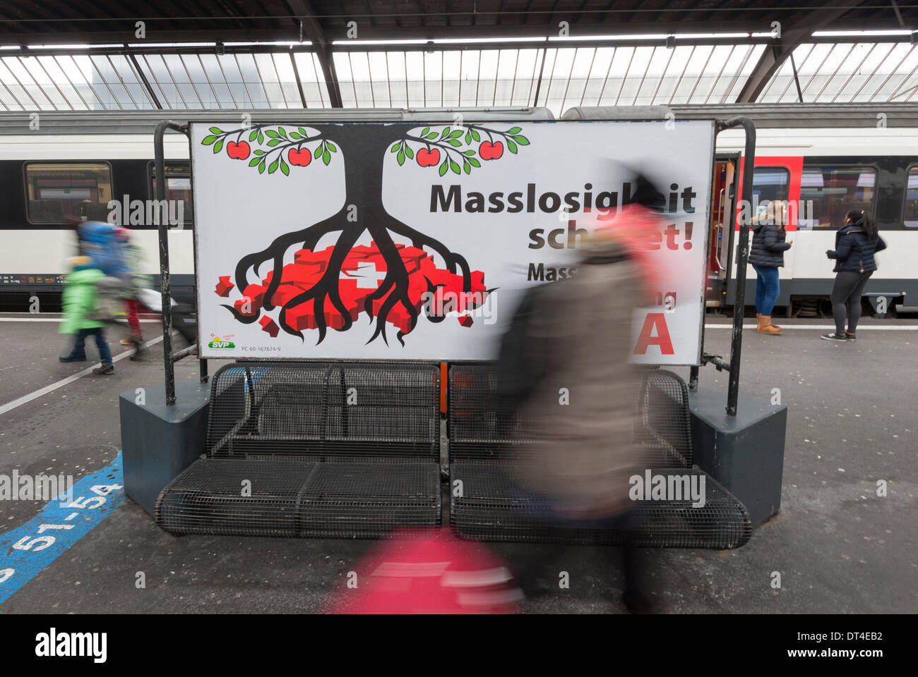 ZURICH, SUISSE, 8 mai 2014 : les voyageurs à une plate-forme de la gare centrale de Zurich se précipitent par référendum affiche de campagne par parti de droite UDC "pour mettre l'immigration de masse" un jour avant le referndum national a lieu. Le prochain référendum suisse vise à rétablir des quotas serrés sur l'immigration en provenance des pays de l'UE et pourrait (si elle est acceptée par les Suisses) pour mettre un terme les accords bilatéraux avec l'UE. treatys Crédit : Erik Tham/Alamy Live News Banque D'Images
