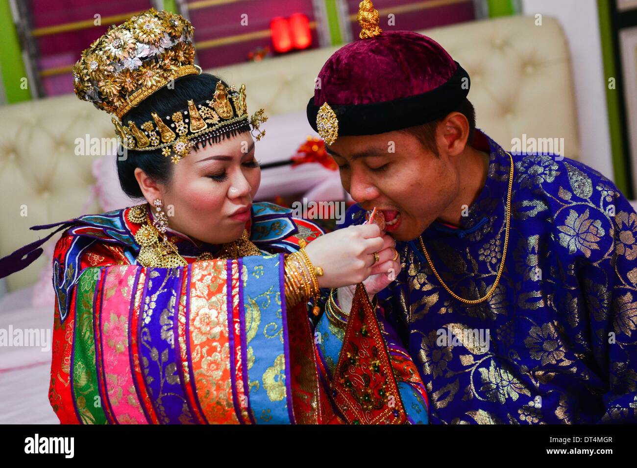 Melaka, Malaisie. Feb 8, 2014. La mariée alimente un bonbon à l'époux au cours de leur cérémonie de mariage Baba Nyonya tenue à Melaka, Malaisie, le 8 février, 2014. Le baba Nyonya (ou Peranakan) est une communauté minoritaire vivant dans le détroit de Malacca. Baba Nyonya désigne les hommes et les femmes signifie. Ils sont des descendants de la 15e et 16e siècle, les immigrants chinois qui sont venus ici en tant que commerçants avant l'époque coloniale, s'est installé dans l'archipel malais et adaptés à la langue et la culture locale. © Chong Chung Voon/Xinhua/Alamy Live News Banque D'Images