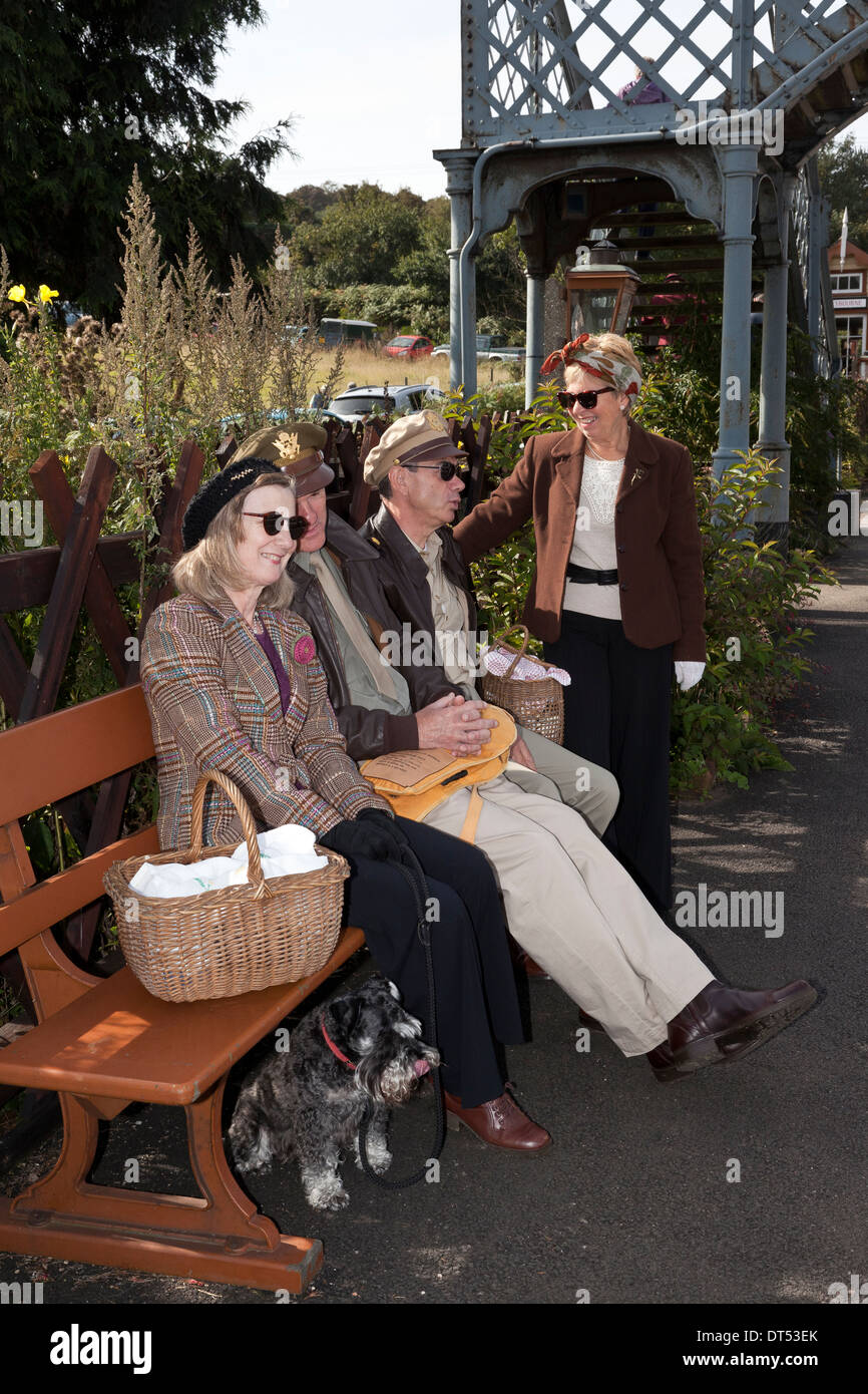 Quatre personnes en attente à la gare en costume des années 1940 Banque D'Images