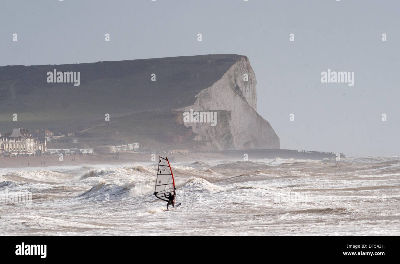 Un windsurfer batailles contre les vagues au large de Tide Mills beach Newhaven aujourd'hui que les tempêtes continuent de battre la côte sud de la Grande-Bretagne . Seaford Head falaises peut être vu dans la distance Banque D'Images