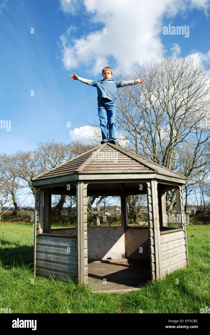 Un petit garçon sur le toit d'une maison d'été Banque D'Images