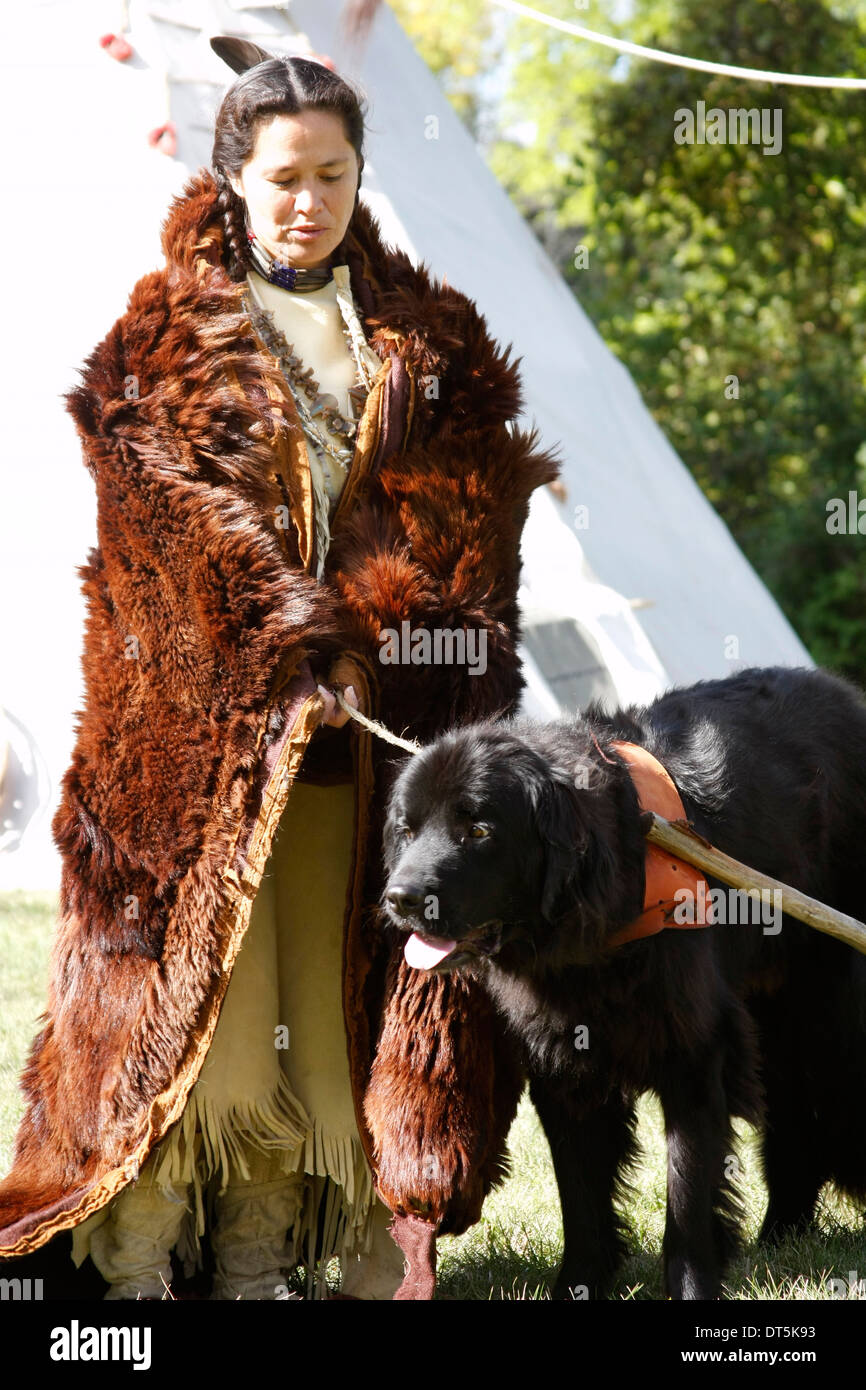 Un Amérindien Sioux Lakota femme indienne dans une peau de bison avec un chien travois Banque D'Images