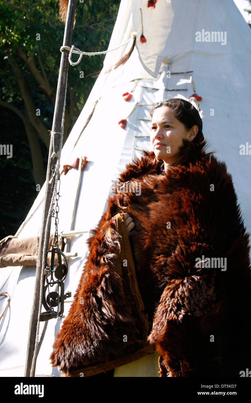 Un Amérindien Sioux Lakota femme indienne dans une peau de bison par un tipi Banque D'Images