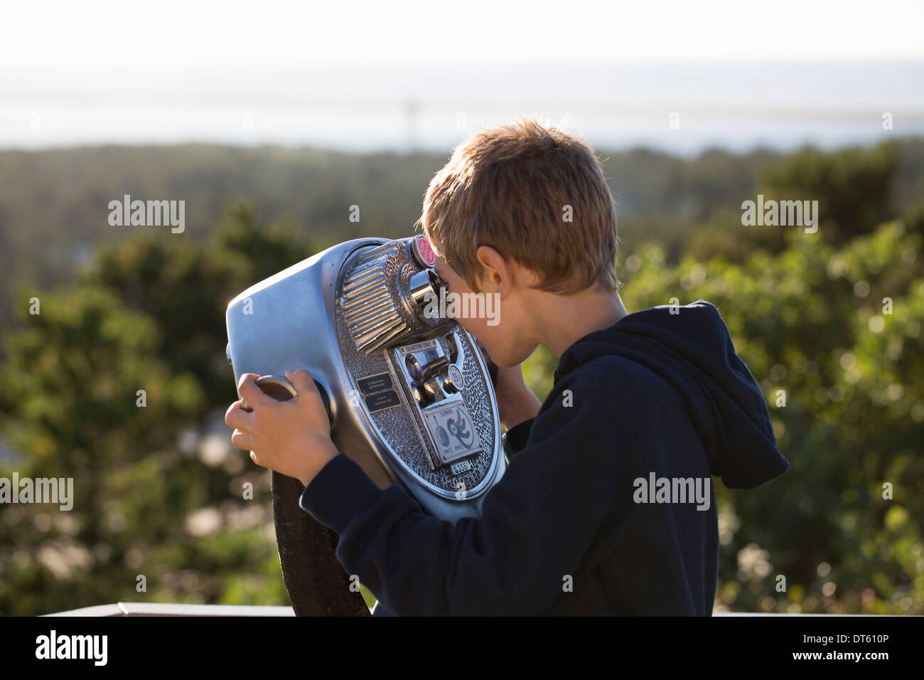 Coin operated Boy using binoculars Banque D'Images
