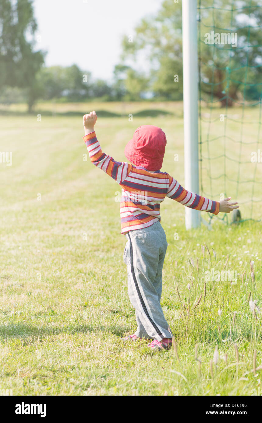 Jeune fille jouant avec un filet de but de football (soccer) Banque D'Images