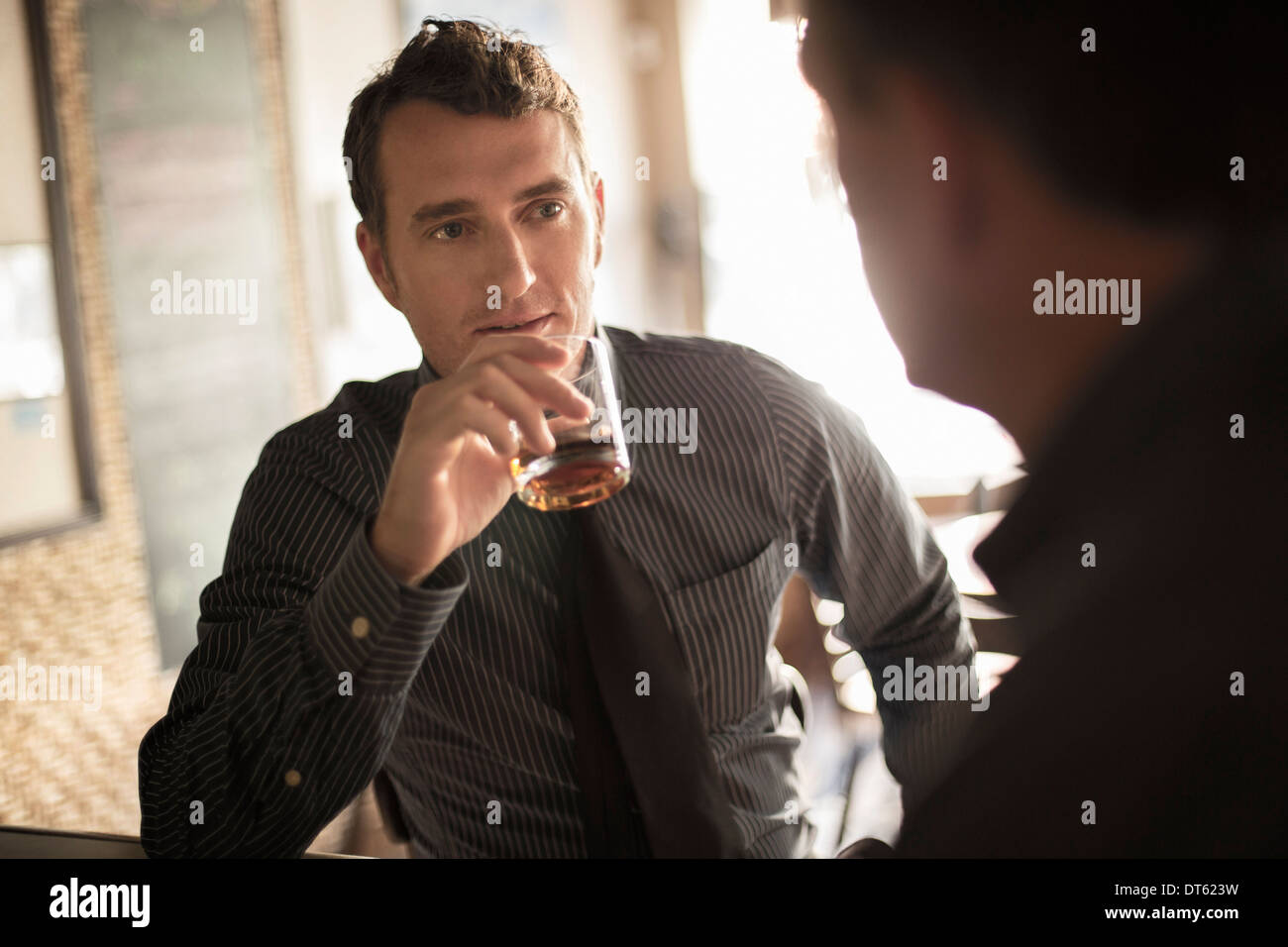 Deux hommes d'avoir un verre au bar à vin Banque D'Images