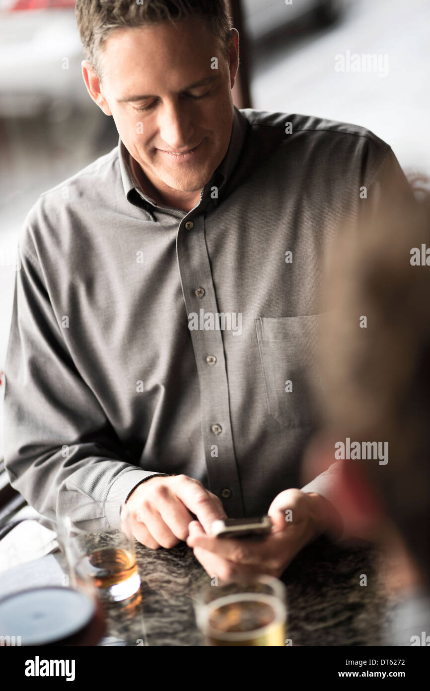 Businessman using cellphone dans un bar à vin Banque D'Images