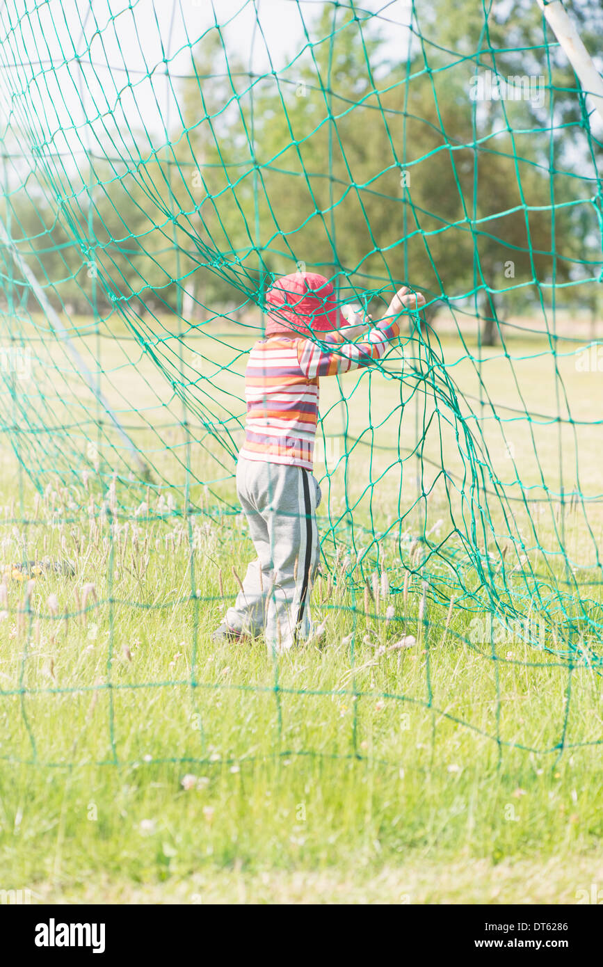 Jeune fille jouant avec un filet de but de football (soccer) Banque D'Images