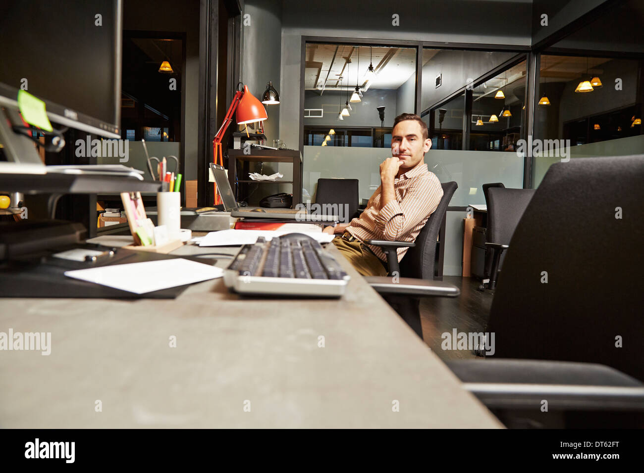 Portrait of businessman sitting at desk in office Banque D'Images