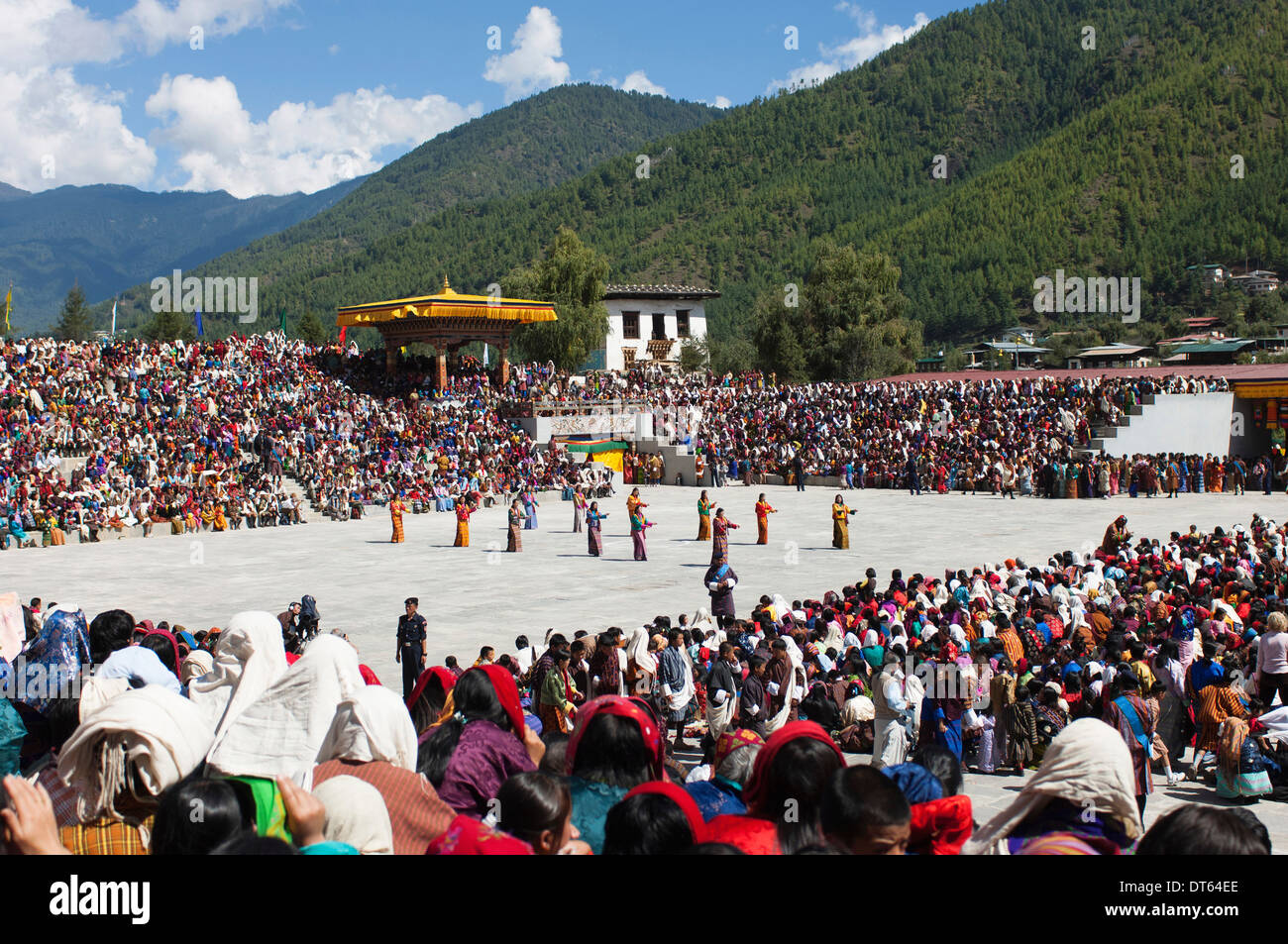 Le Bhoutan, l'Asie du Sud, Thimpu Dzong, danseurs dans la cour en festival avec la foule de gens dans les peuplements à regarder. Banque D'Images