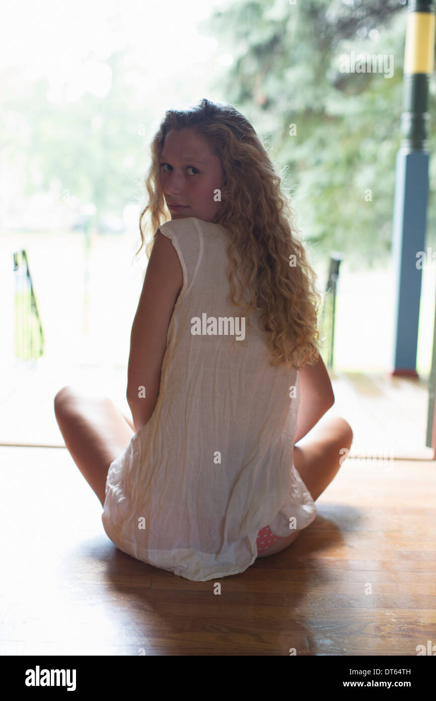 Teenage girl sitting at front door Banque D'Images