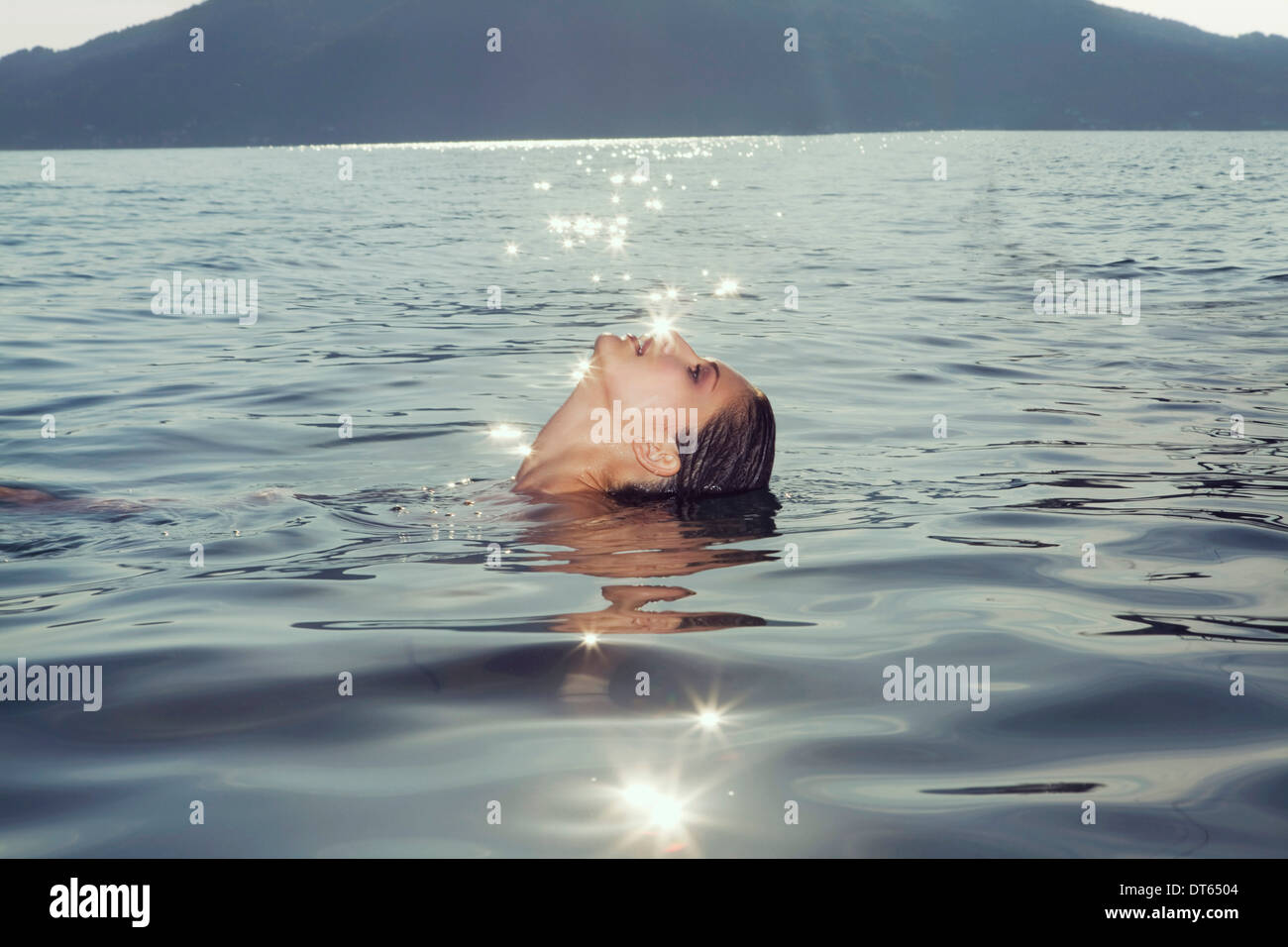 Jeune femme flottant sur le lac en Attesee, Autriche Banque D'Images