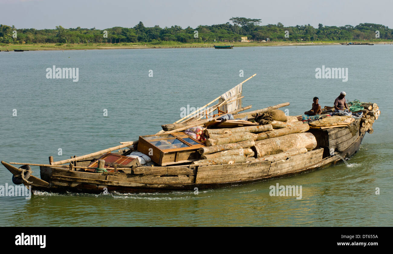 Le Bangladesh, l'Asie du Sud, le bateau lourdement chargé avec une cargaison de bois et meubles sur rivière. Banque D'Images