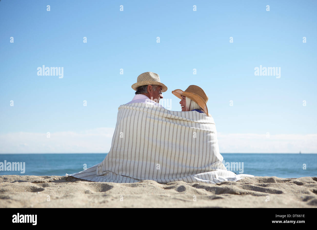 Couple portant des chapeaux de paille sur la plage Banque D'Images