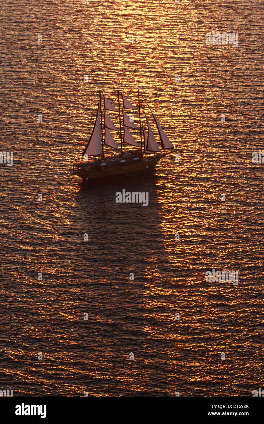 Un trois-mâts toutes voiles dehors avec voilier sur la mer au coucher du soleil. Banque D'Images