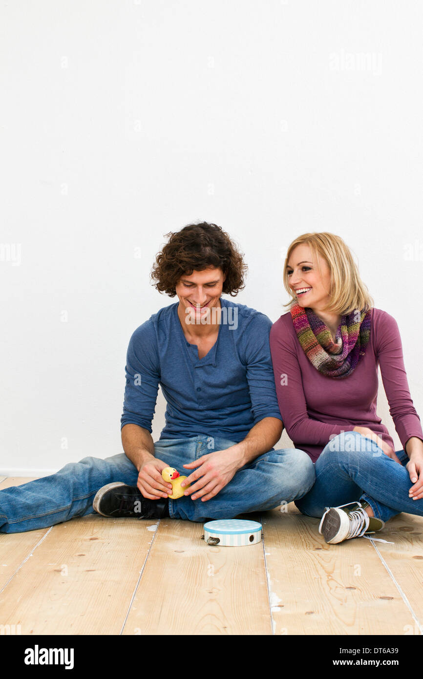 Studio shot of woman sitting on floor with toys Banque D'Images