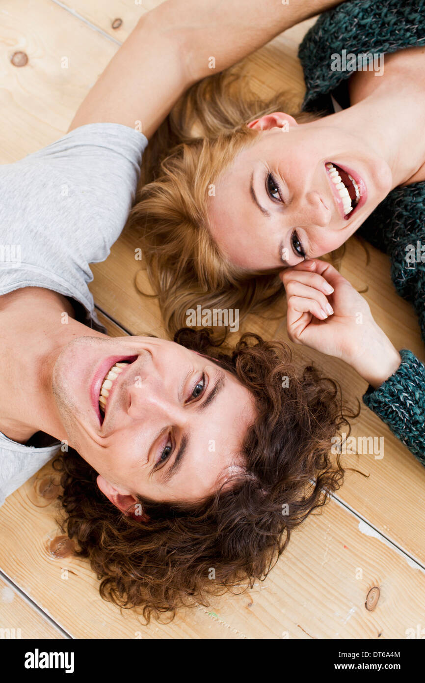 Studio shot couple lying on floor Banque D'Images