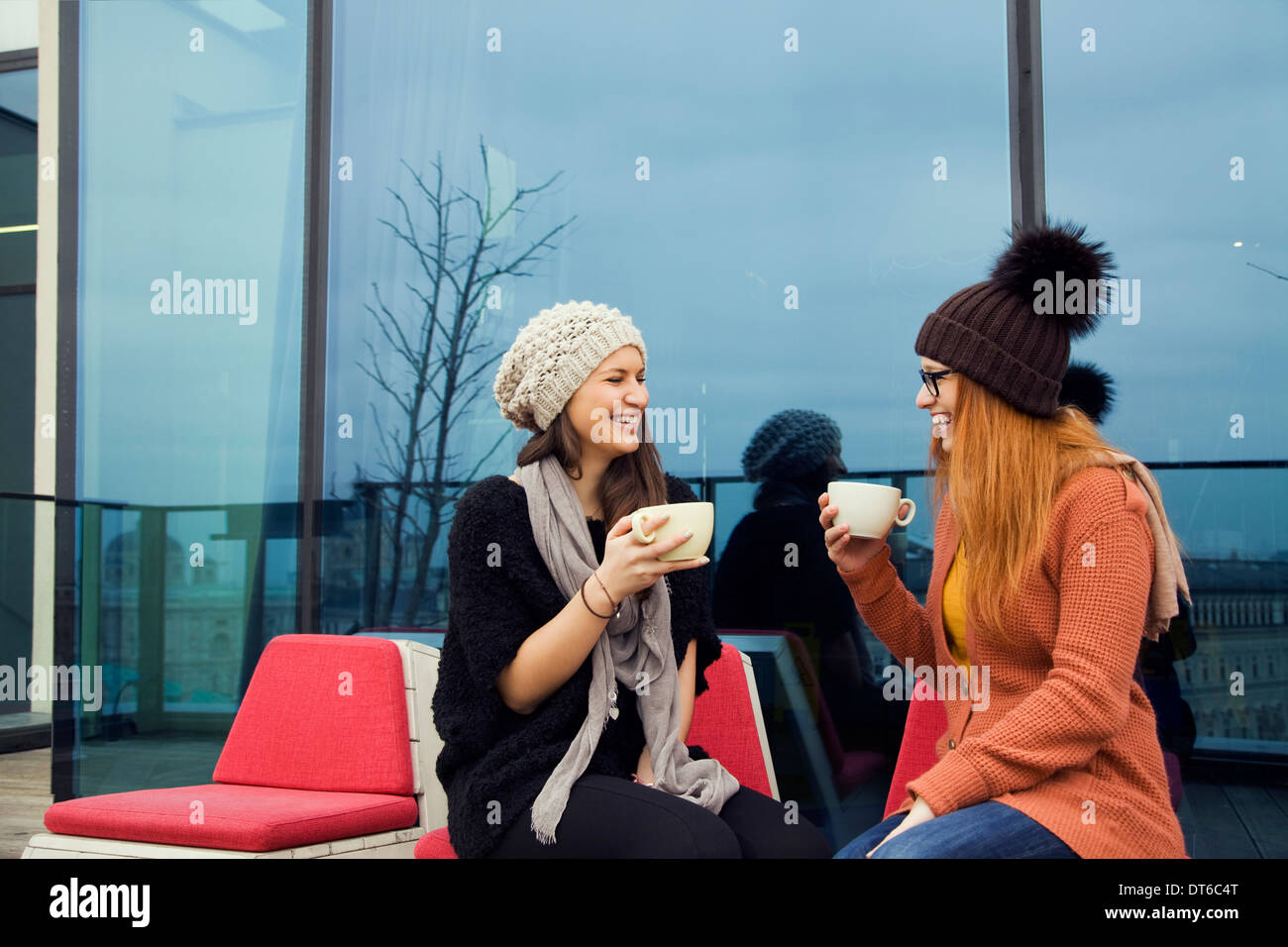 Deux jeunes femmes adultes appréciant café sur toit-terrasse Banque D'Images