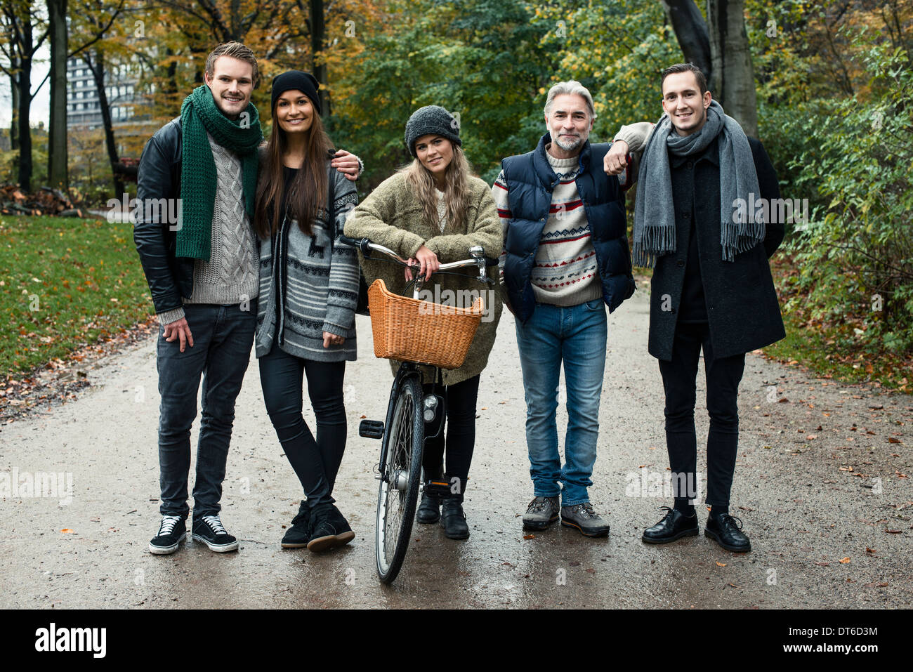 Friends posing with bicycle in woods Banque D'Images