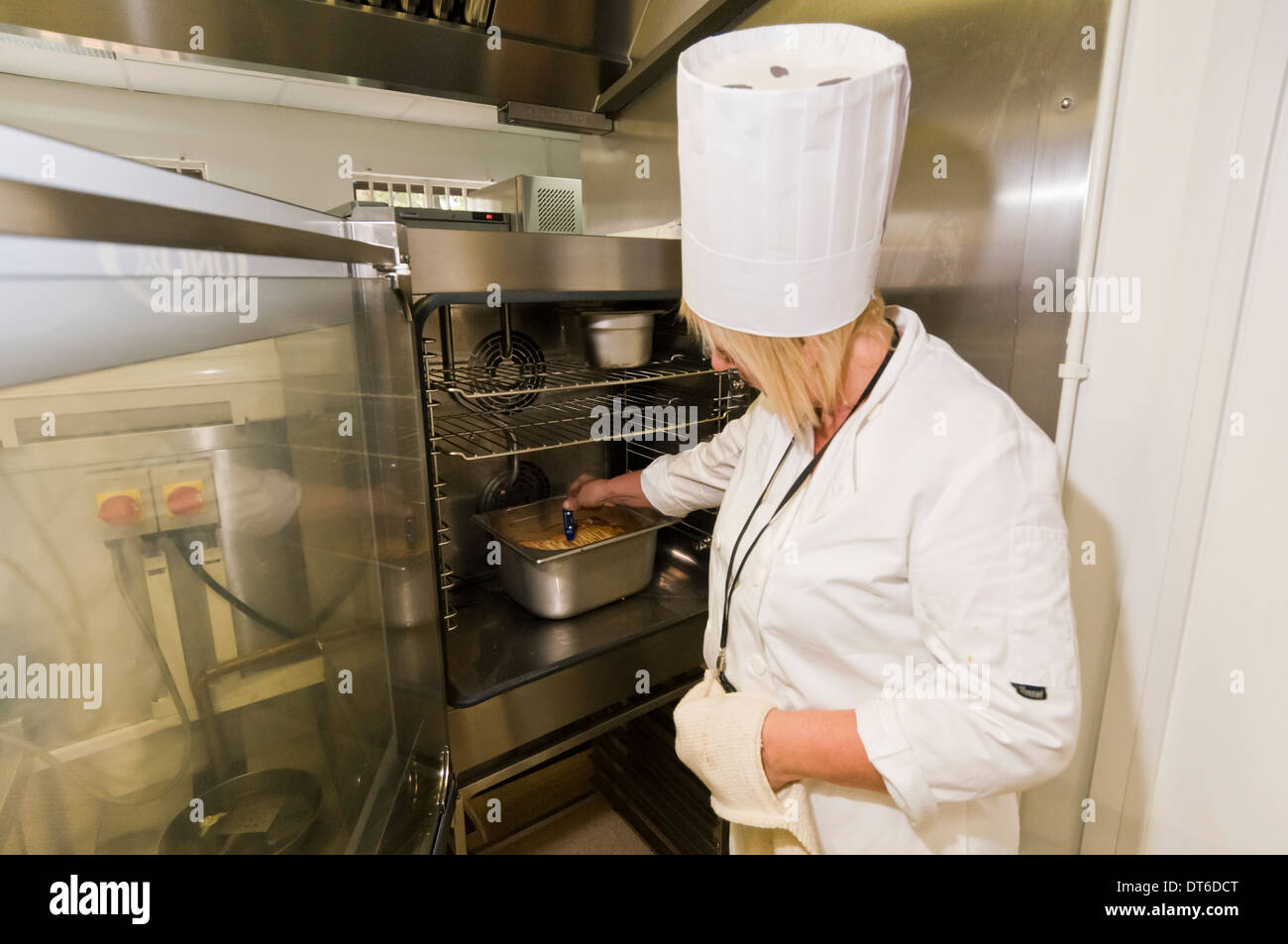Femme chef de préparer des aliments dans une cuisine commerciale Banque D'Images