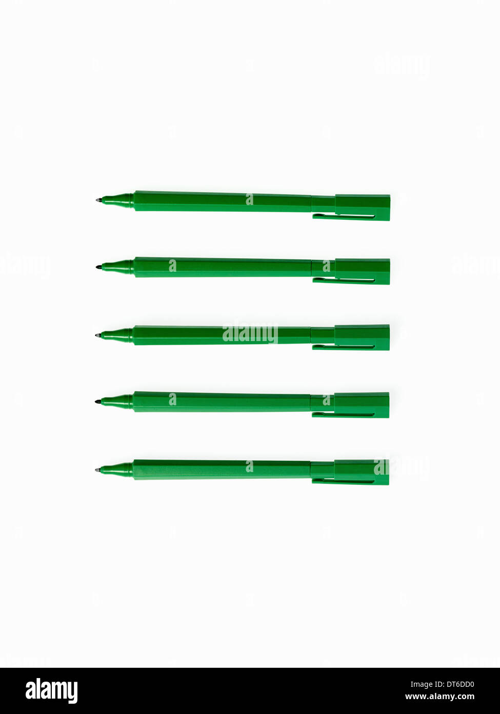 Les fournitures de bureau. Stylos feutre de couleur verte, plumes et pen top cas, disposés en une ligne. Banque D'Images