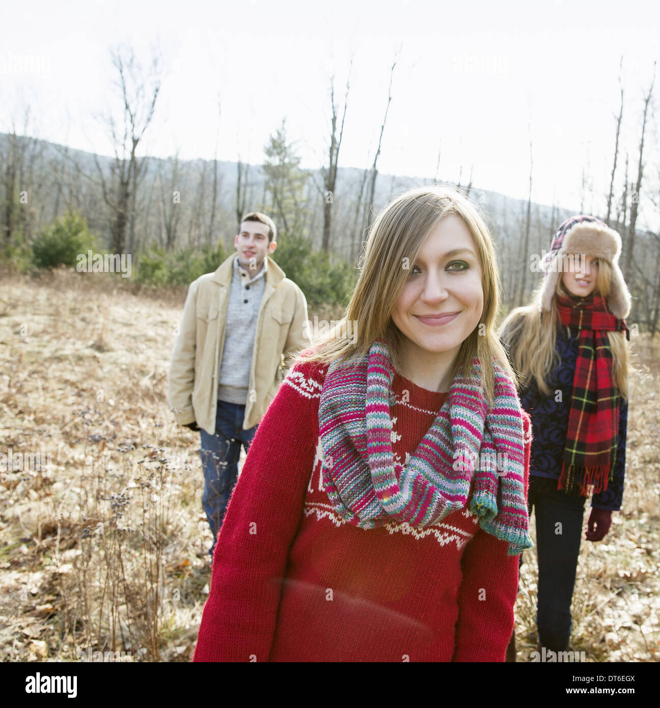 Un groupe de trois personnes, un homme et deux femmes, sur une promenade sur une journée d'hiver. Banque D'Images