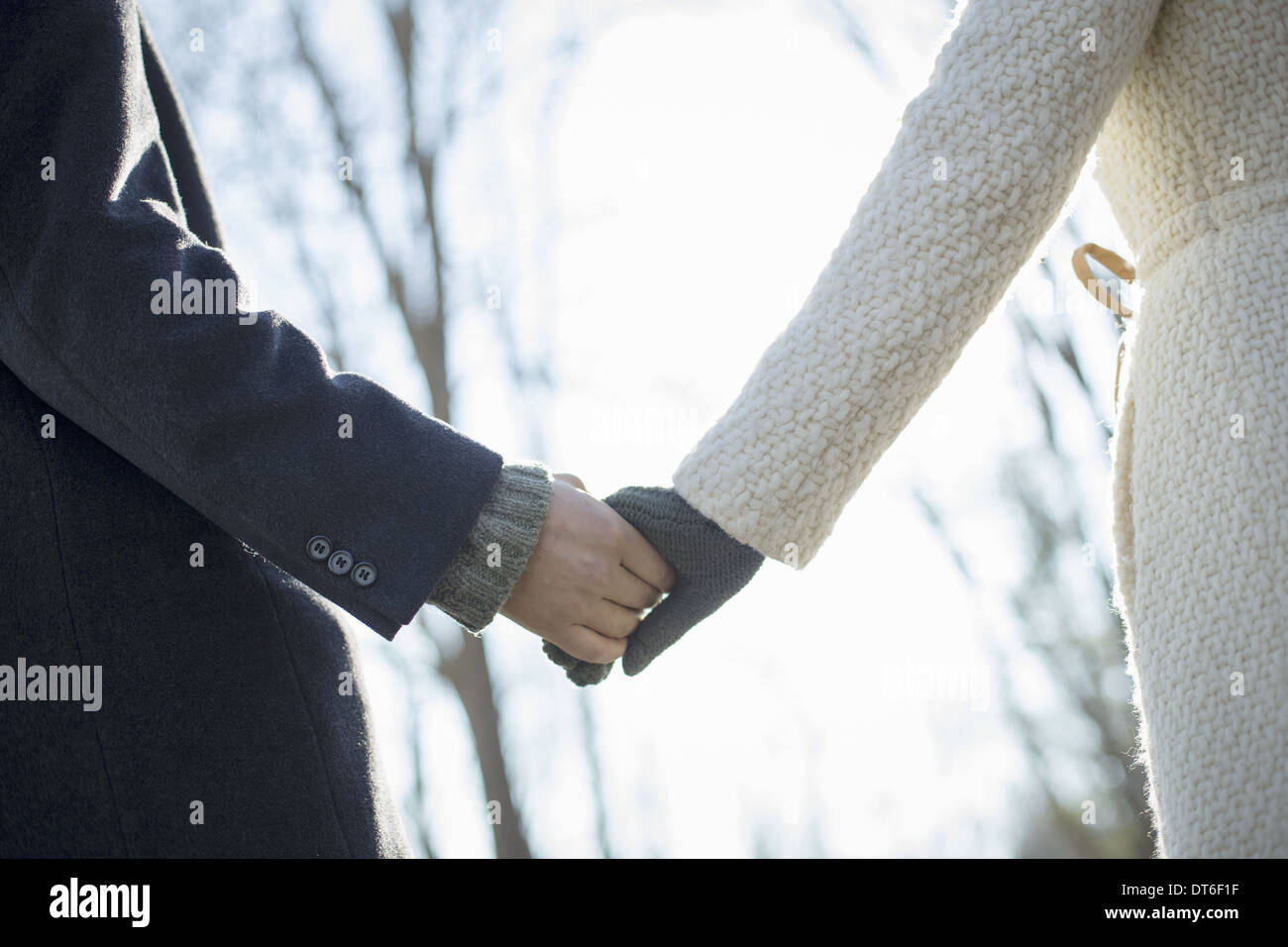 Deux personnes, un couple, un homme et une femme dans les bois sur une journée d'hiver. Se tenant la main. Banque D'Images